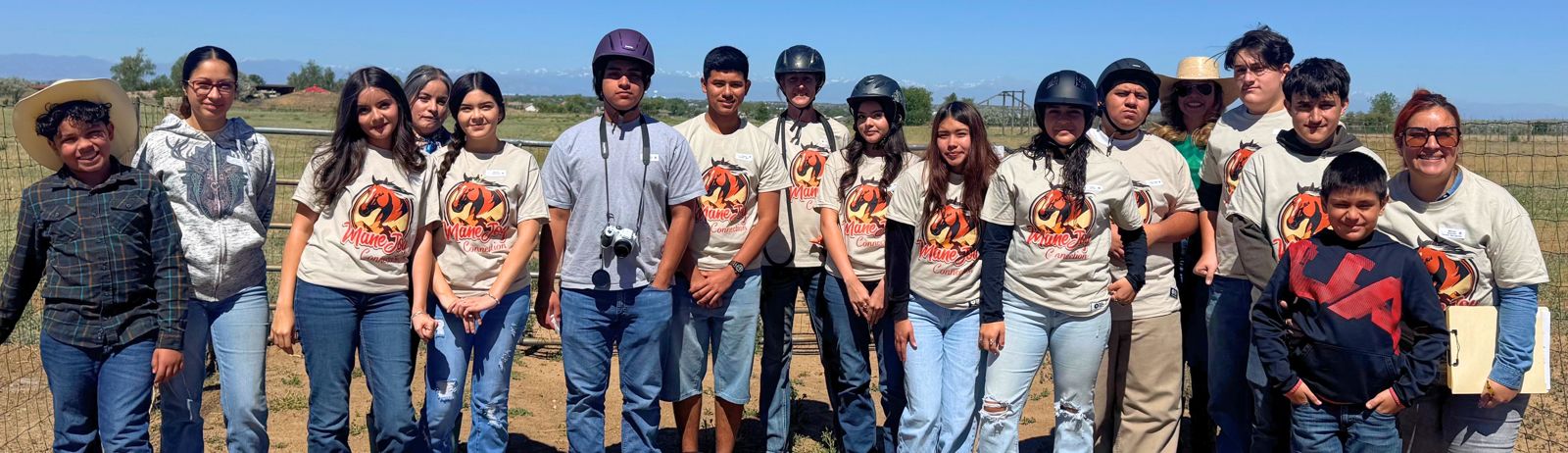 A large group of smiling Youth Natural Leaders in matching Mane Joy T-shirts standing together at SonFlower Ranch